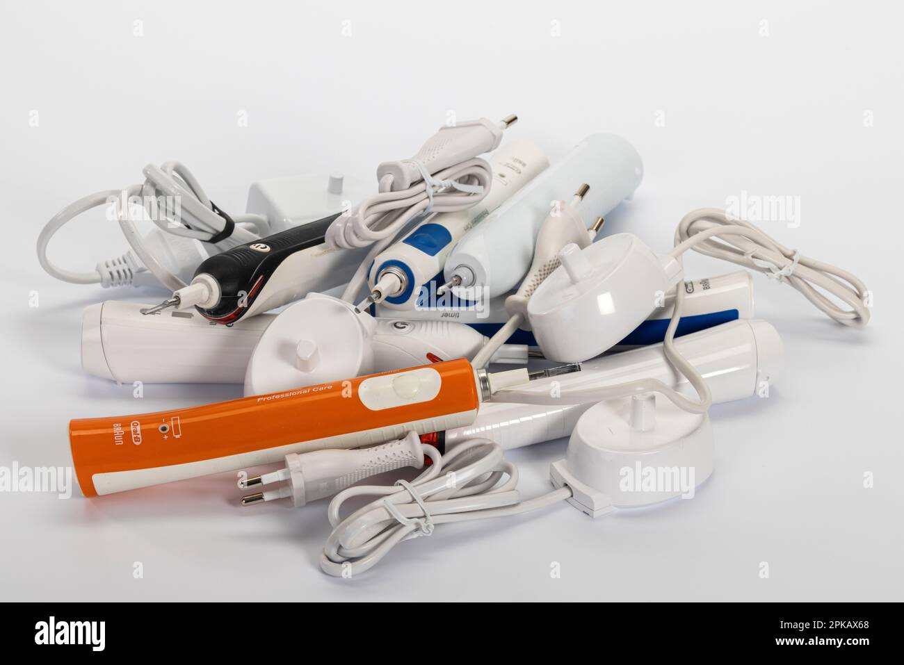 Spazzolini elettrici difettosi, caricabatterie, marche diverse, immagine simbolo, smaltimento di rifiuti elettronici, sfondo bianco, Foto Stock