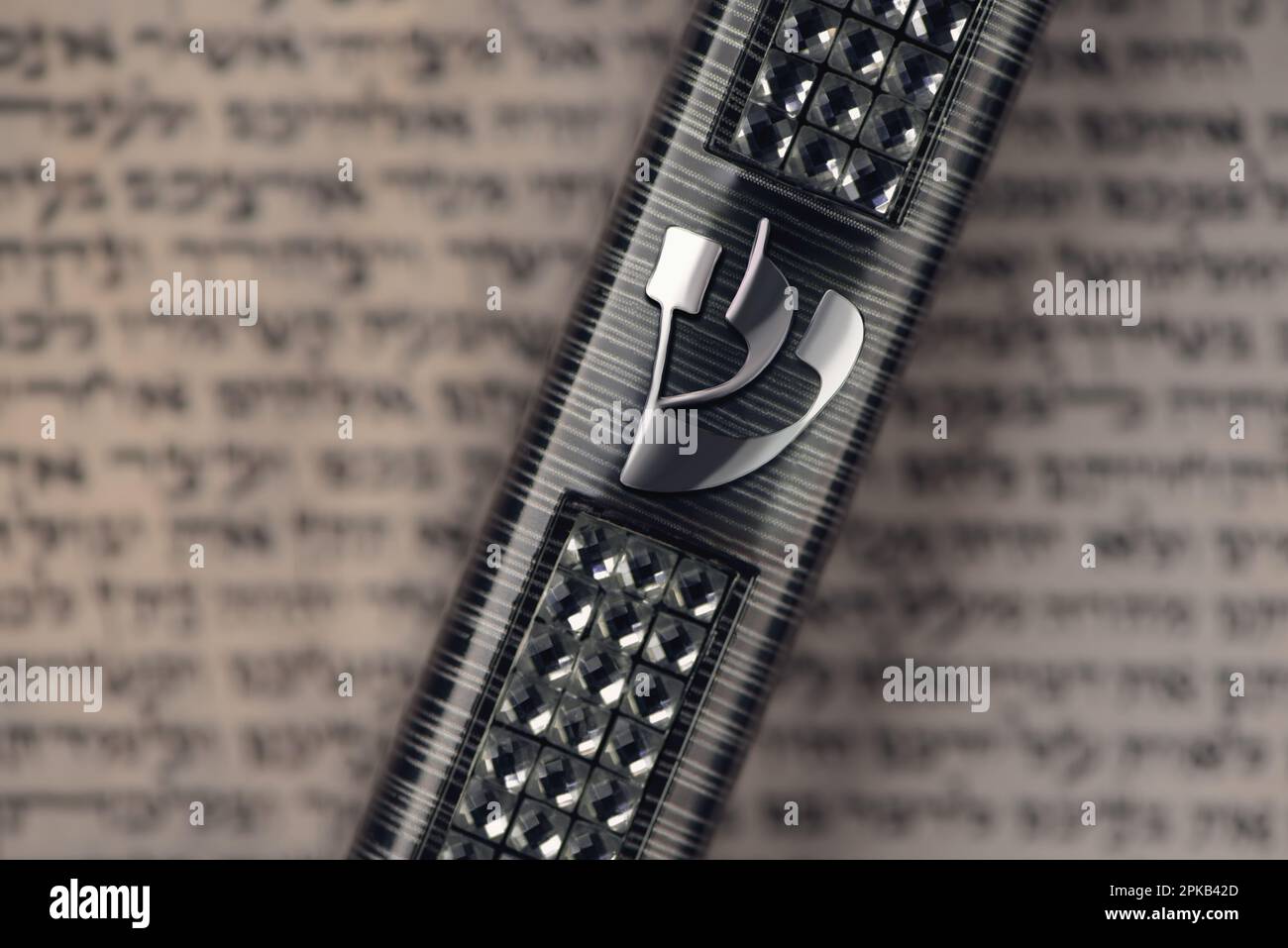 Caso di Mezuzah che si posa su pergamena offuscata con preghiera ebraica Shema Yisrael in ebraico, comandamento di mezuzah. Simbolo del giudaismo. Primo piano. Messa a fuoco selettiva Foto Stock