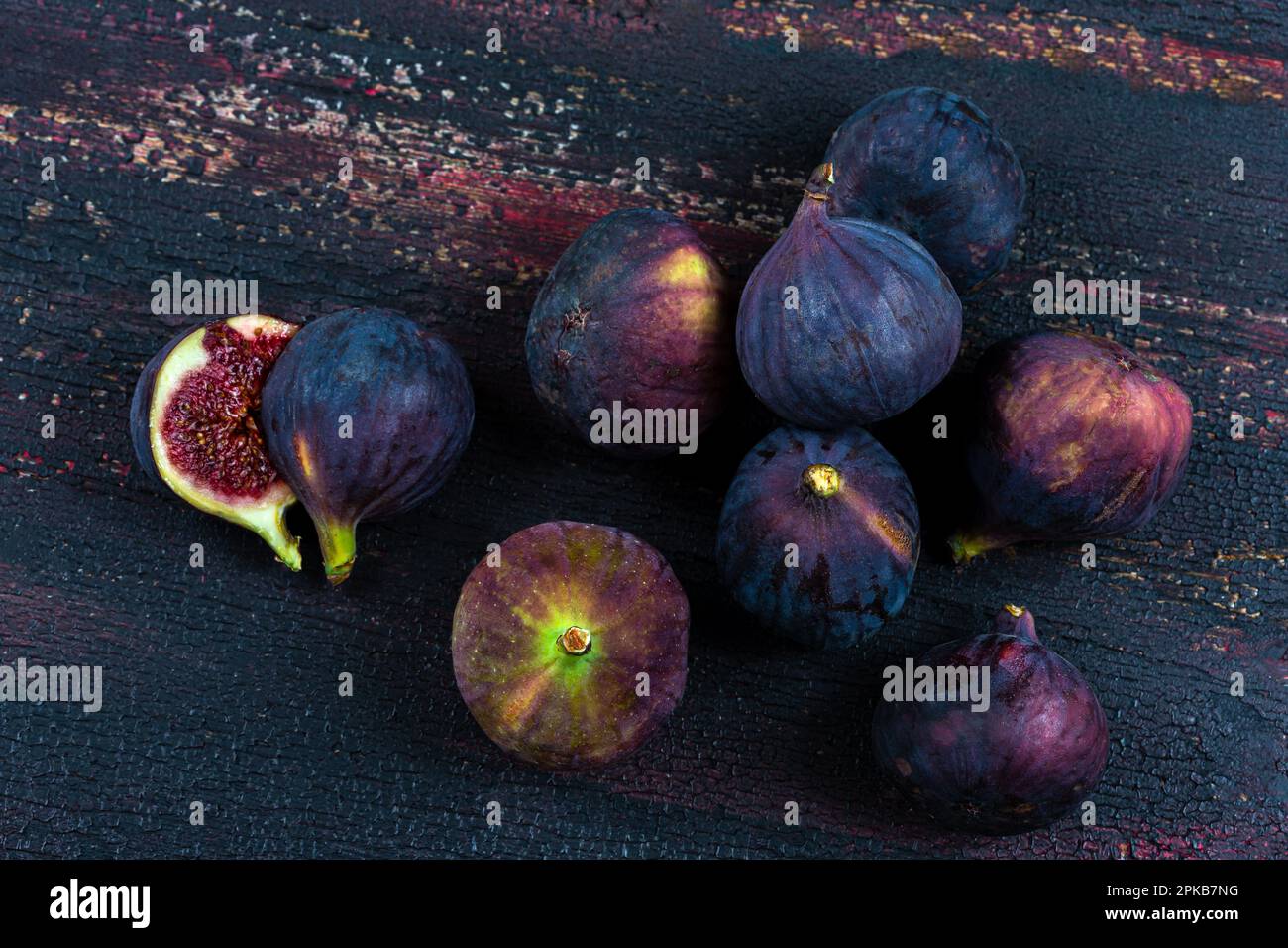 Raccolta di fichi neri ricchi di minerali e oligoelementi su una vecchia tavola. Foto Stock