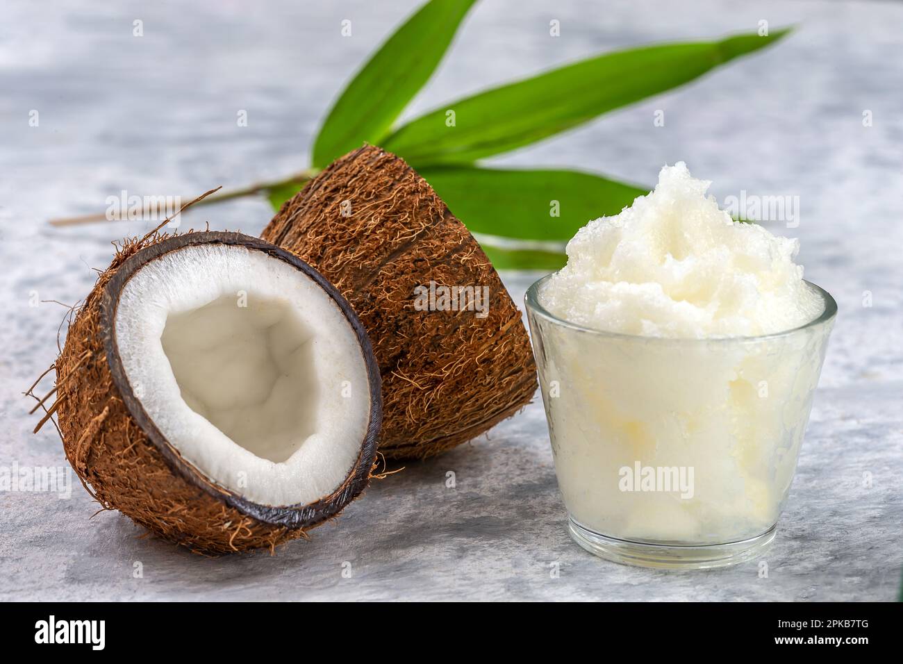 Olio di cocco in una tazza circondata dalla frutta. Foto Stock