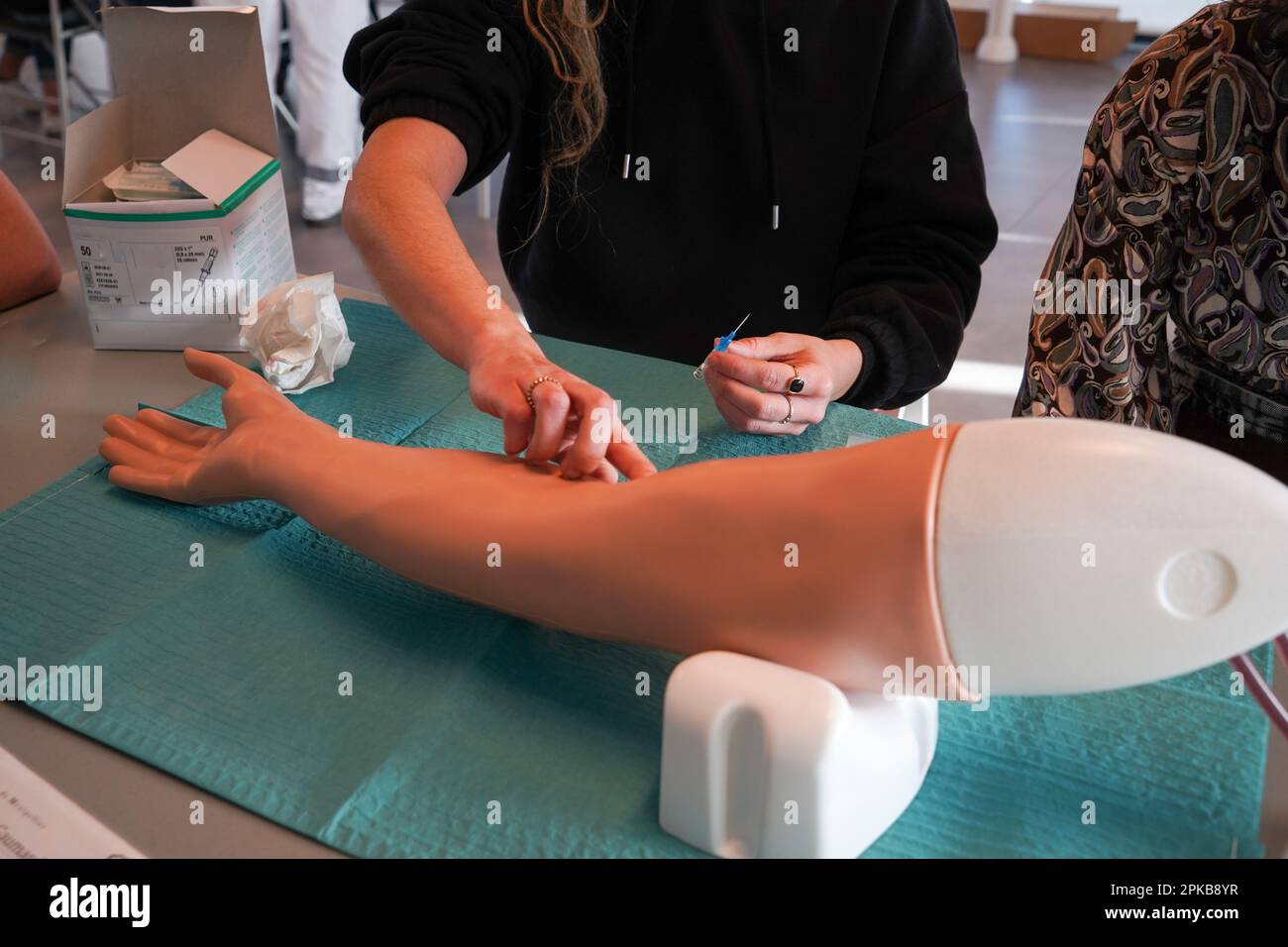 5th anni di studenti di medicina durante un workshop di IV tirocinio. Gli studenti si allenano su un braccio arterioso consentendo la puntura arteriosa e venosa per il campionamento del sangue. Foto Stock