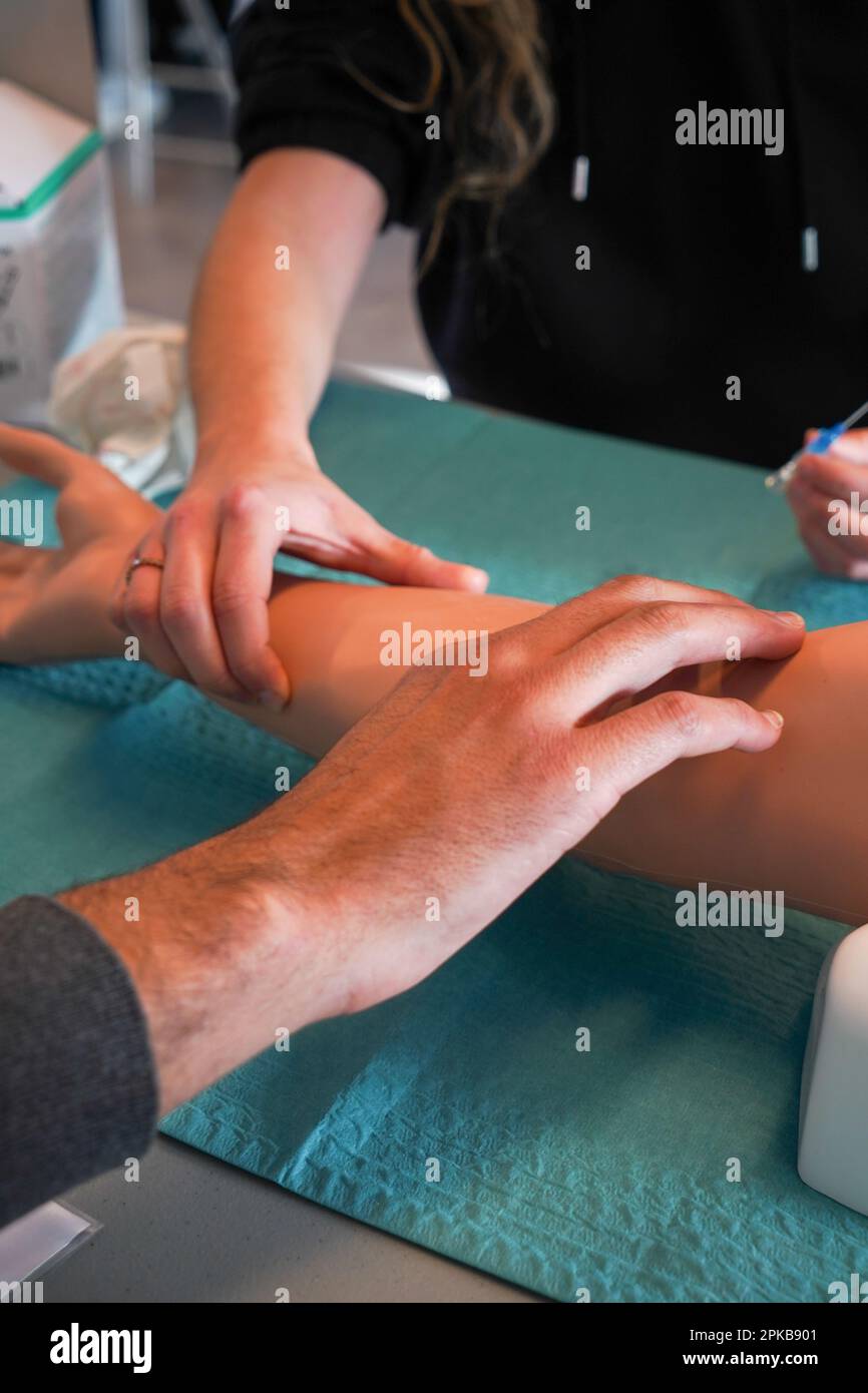 5th anni di studenti di medicina durante un workshop di IV tirocinio. Gli studenti si allenano su un braccio arterioso consentendo la puntura arteriosa e venosa per il campionamento del sangue. Foto Stock