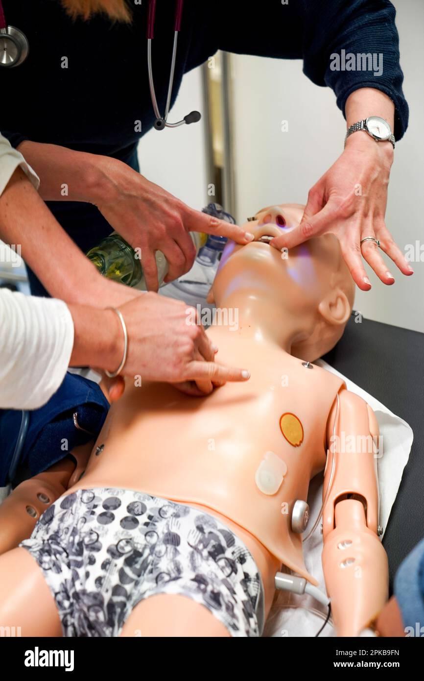 I medici generici sono addestrati alle procedure di emergenza pediatrica. Un medico svolge il ruolo della madre durante l'intervento. Foto Stock