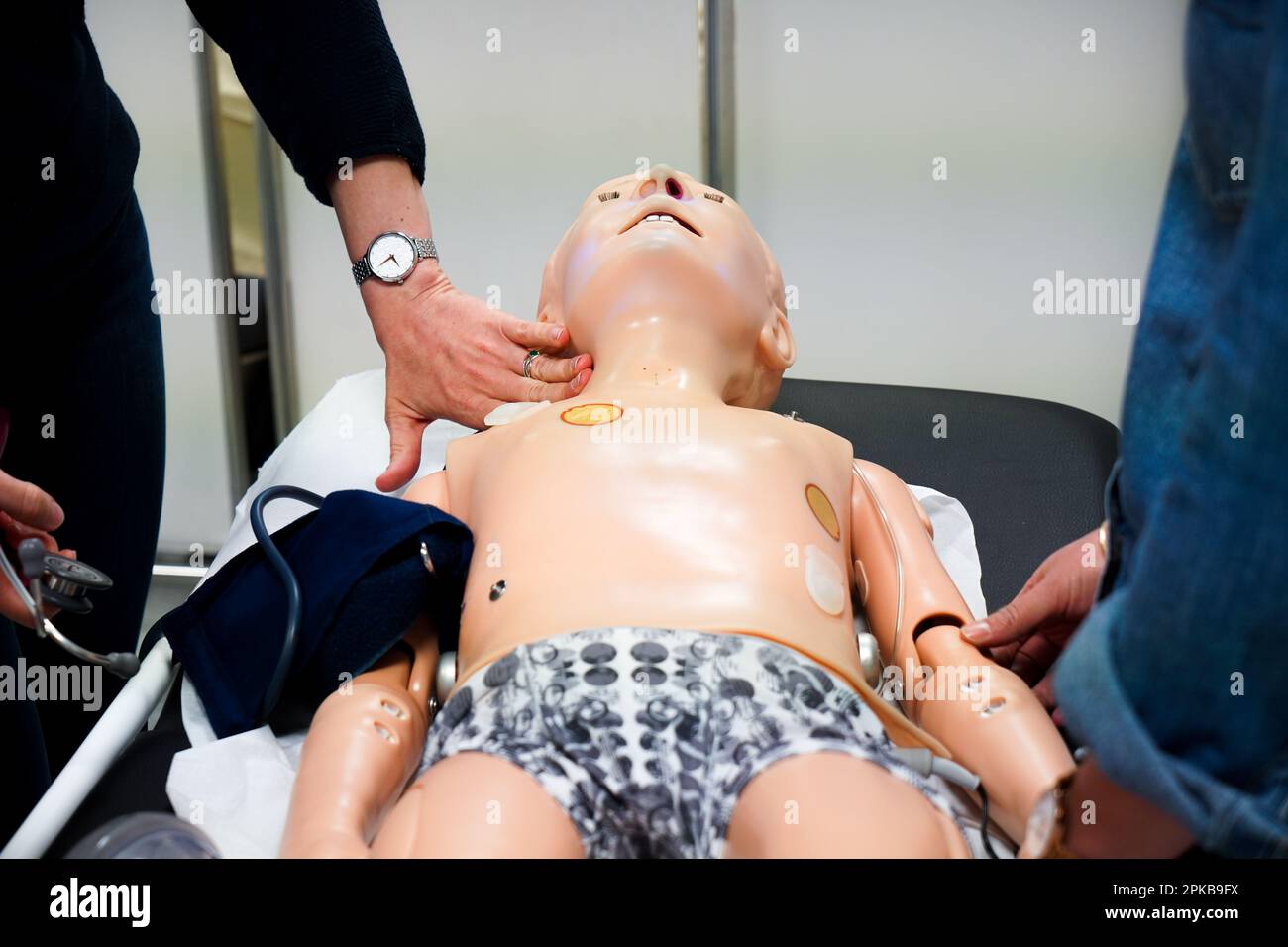 I medici generici sono addestrati alle procedure di emergenza pediatrica. Un medico svolge il ruolo della madre durante l'intervento. Foto Stock