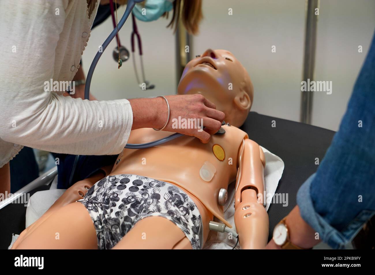 I medici generici sono addestrati alle procedure di emergenza pediatrica. Un medico svolge il ruolo della madre durante l'intervento. Foto Stock