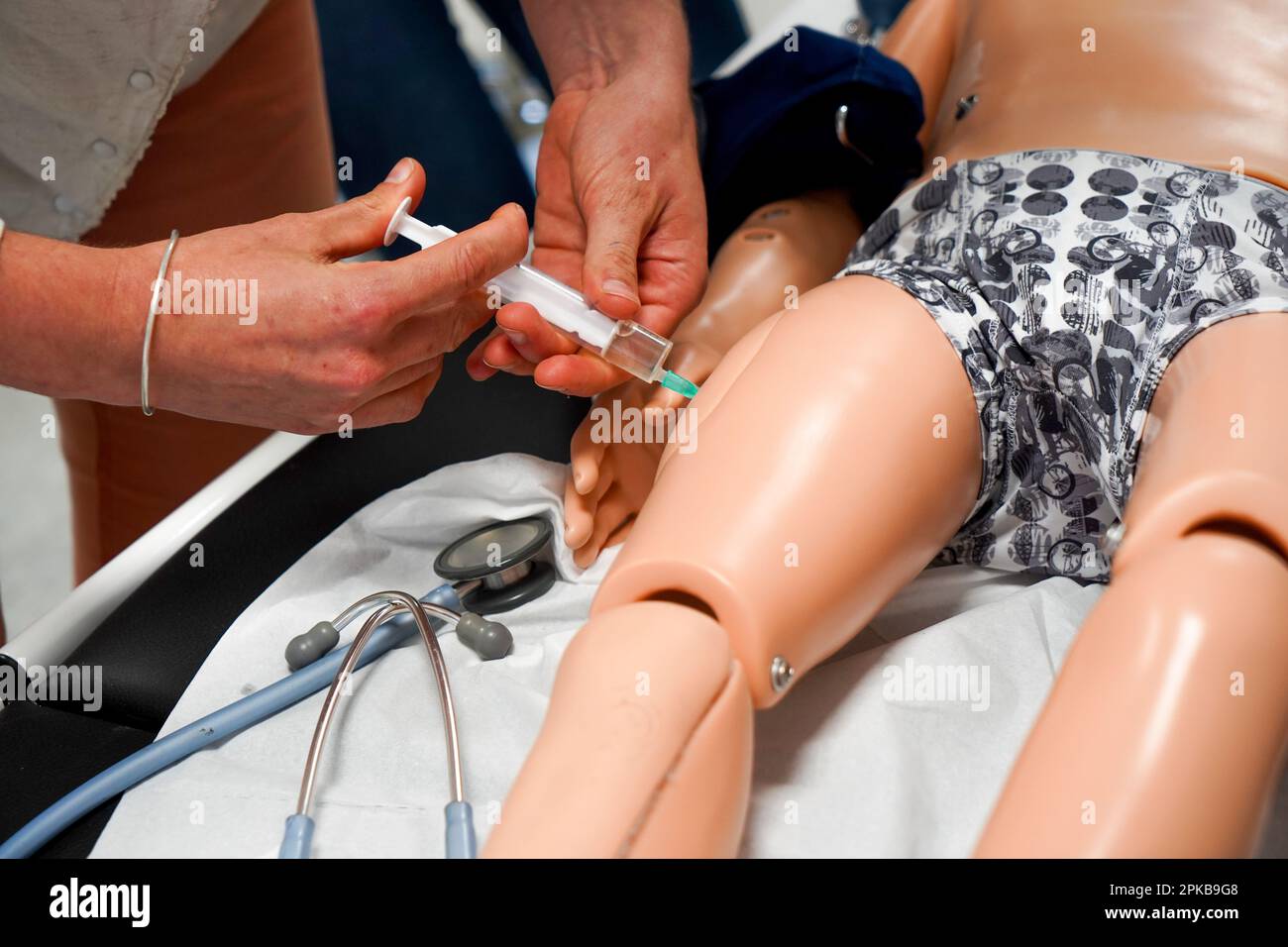 I medici generici sono addestrati alle procedure di emergenza pediatrica. Un medico svolge il ruolo della madre durante l'intervento. Foto Stock