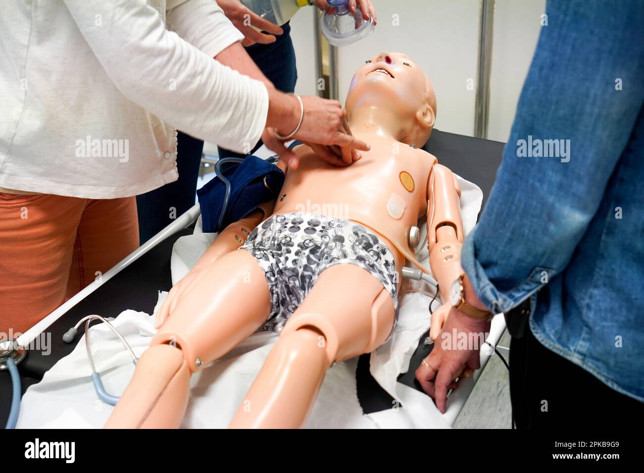 I medici generici sono addestrati alle procedure di emergenza pediatrica. Un medico svolge il ruolo della madre durante l'intervento. Foto Stock