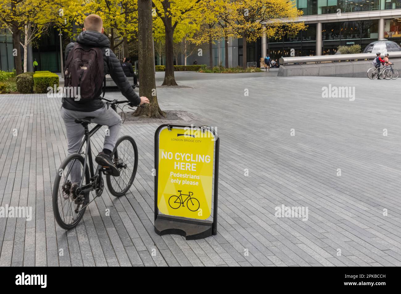 Inghilterra, Londra, giovane ciclista passando da No Cycling Sign Foto Stock