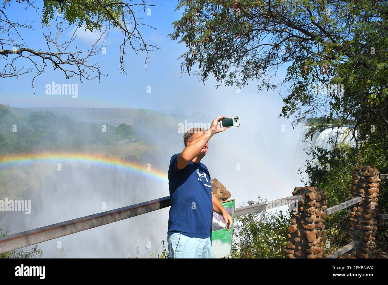 Livingstone, Zambia. 06th Apr, 2023. Un turista fotografa la cascata Victoria al confine tra lo Zambia e lo Zimbabwe. Le possenti Cascate Vittoria sul Fiume Zambezi sono uno dei luoghi turistici piu' visitati in Africa. Victoria Falls si trova proprio al confine tra Zambia e Zimbabwe nell'Africa meridionale. È una delle cascate più alte del mondo. (Foto di Billy Mutai/SOPA Images/Sipa USA) Credit: Sipa USA/Alamy Live News Foto Stock