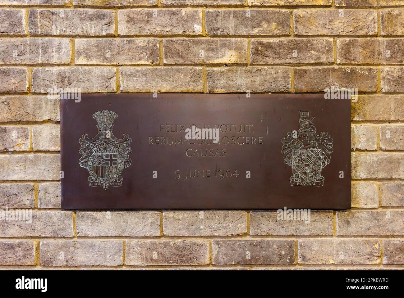 Targa in ottone con il motto "felix qui potuit rerum cognoscere causas" al Churchill College, parte dell'Università di Cambridge, Inghilterra orientale Foto Stock