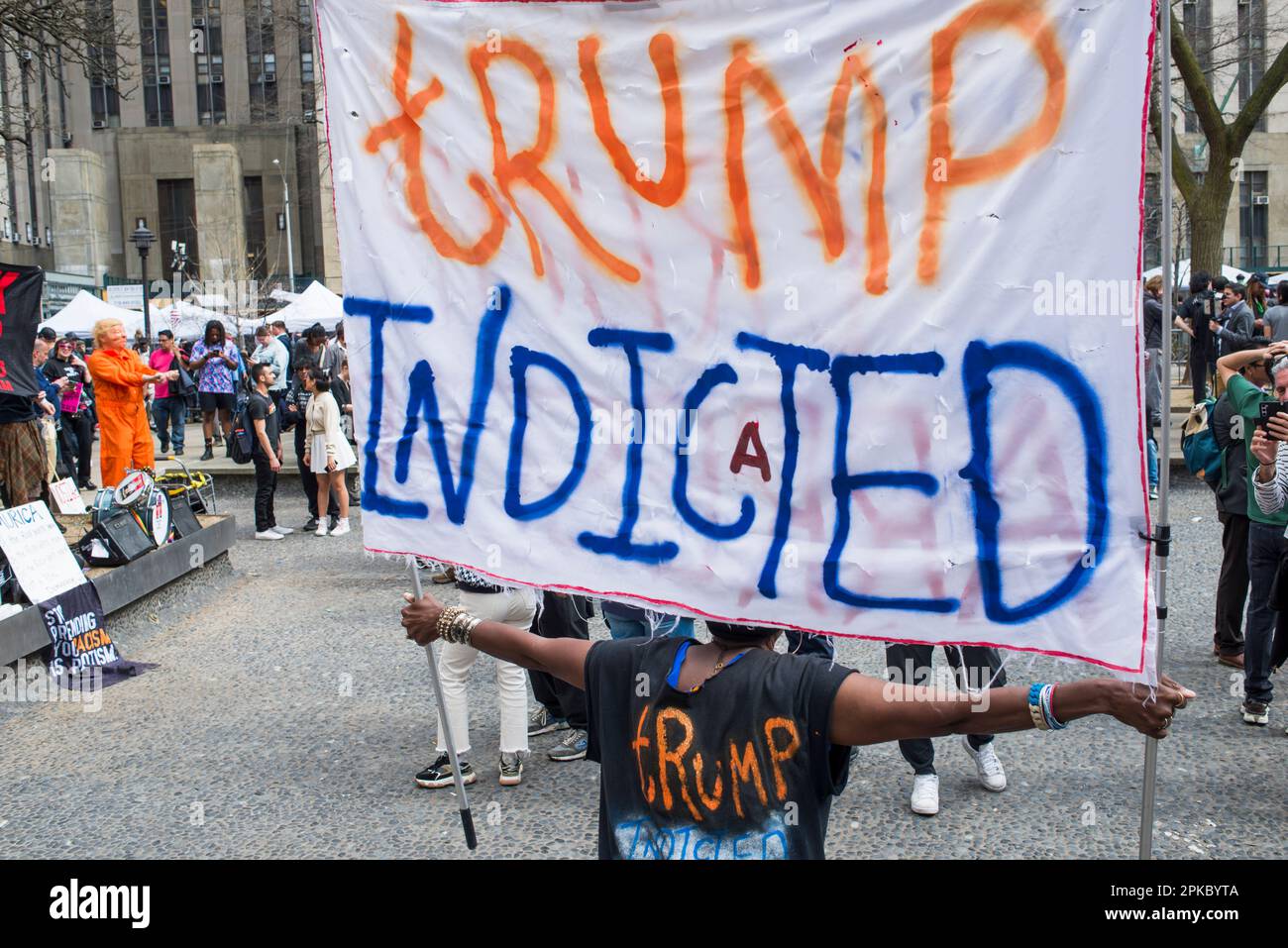Il sostenitore anti-Trump tiene il cartello di accusa di Trump fuori dal Manhattan Criminal Court House, New York, durante l’arrignment di Trump il 04 aprile 2023. Foto Stock