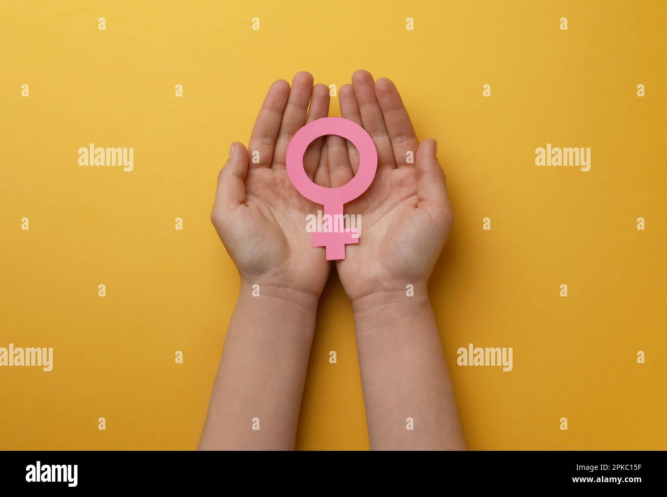 Donna con segno di sesso femminile su sfondo arancione, vista dall'alto Foto Stock