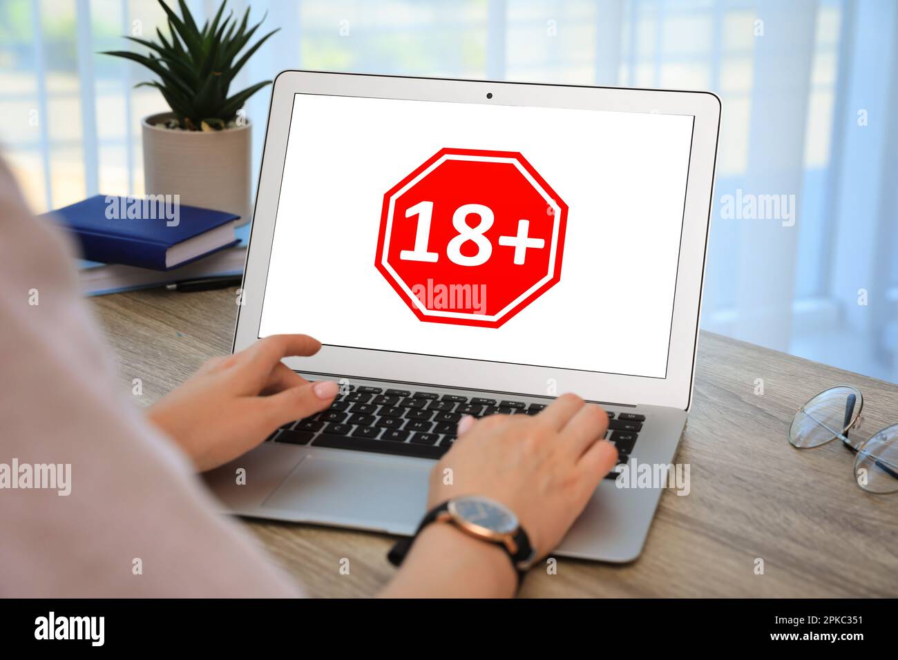 Donna che utilizza un notebook con un limite di età oltre 18 anni in ambienti chiusi, primo piano Foto Stock
