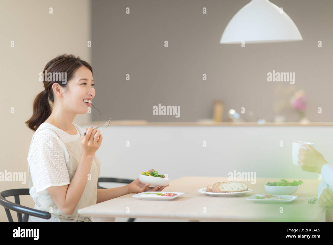 Donna che ha una conversazione mentre mangia Foto Stock