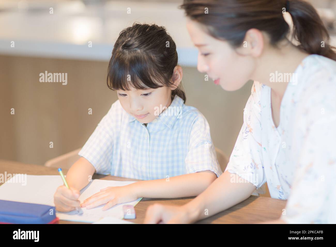 Ragazza che studia con Madre Foto Stock