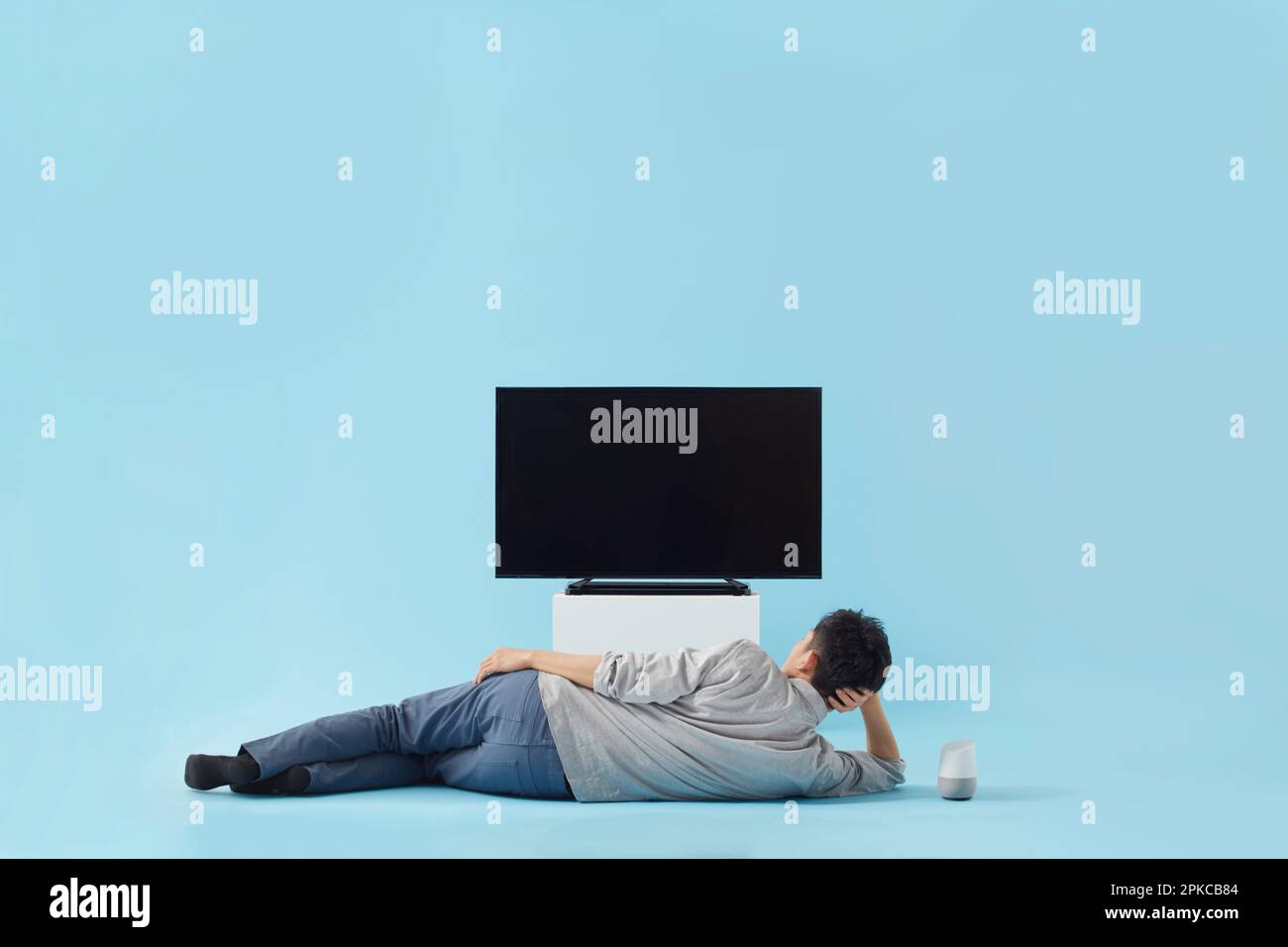 Uomo sdraiato di fronte alla TV Foto Stock
