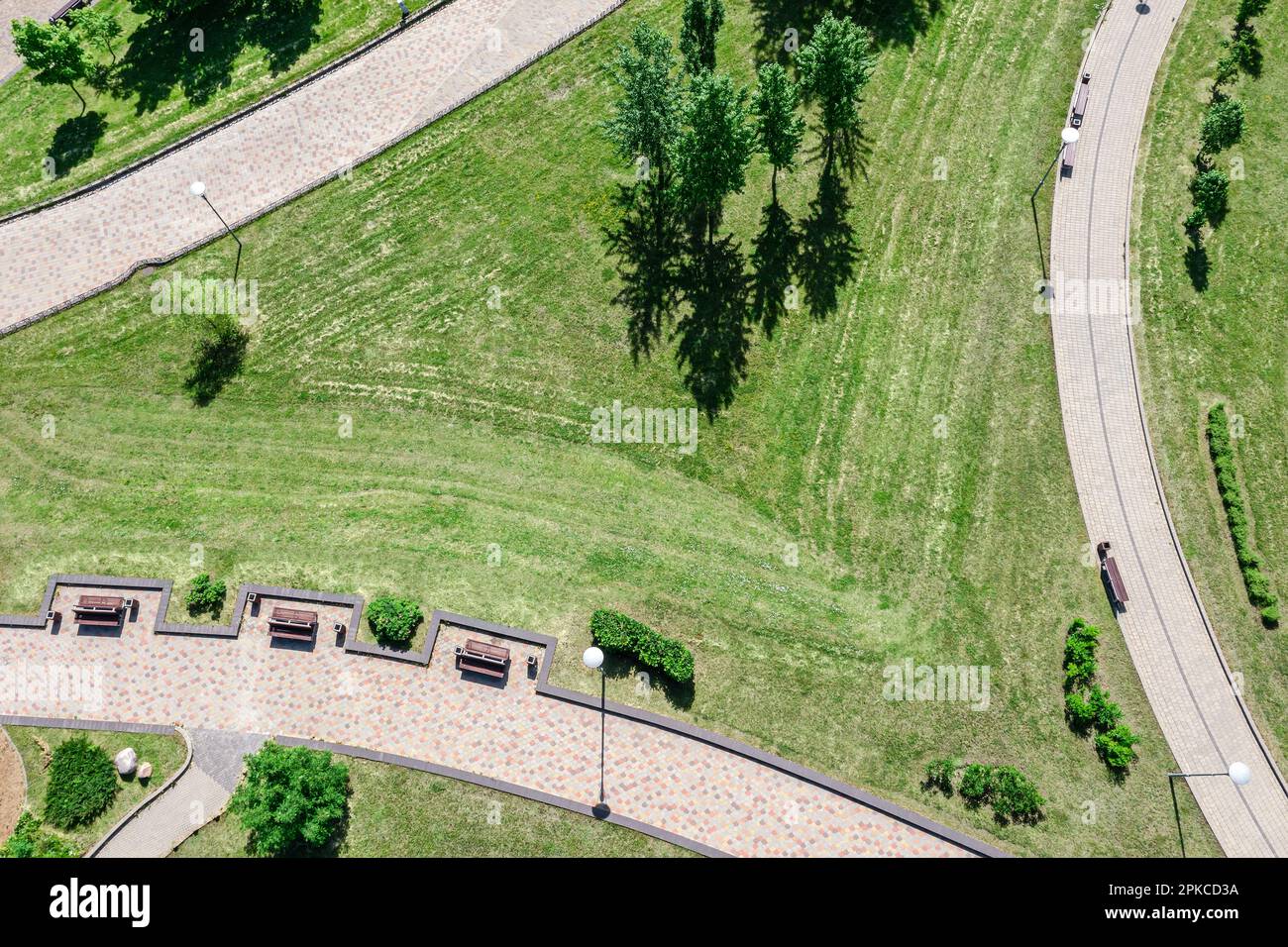 sentieri del parco cittadino. prato verde, alberi, panchine del parco e lanterne. foto drone dall'alto. Foto Stock
