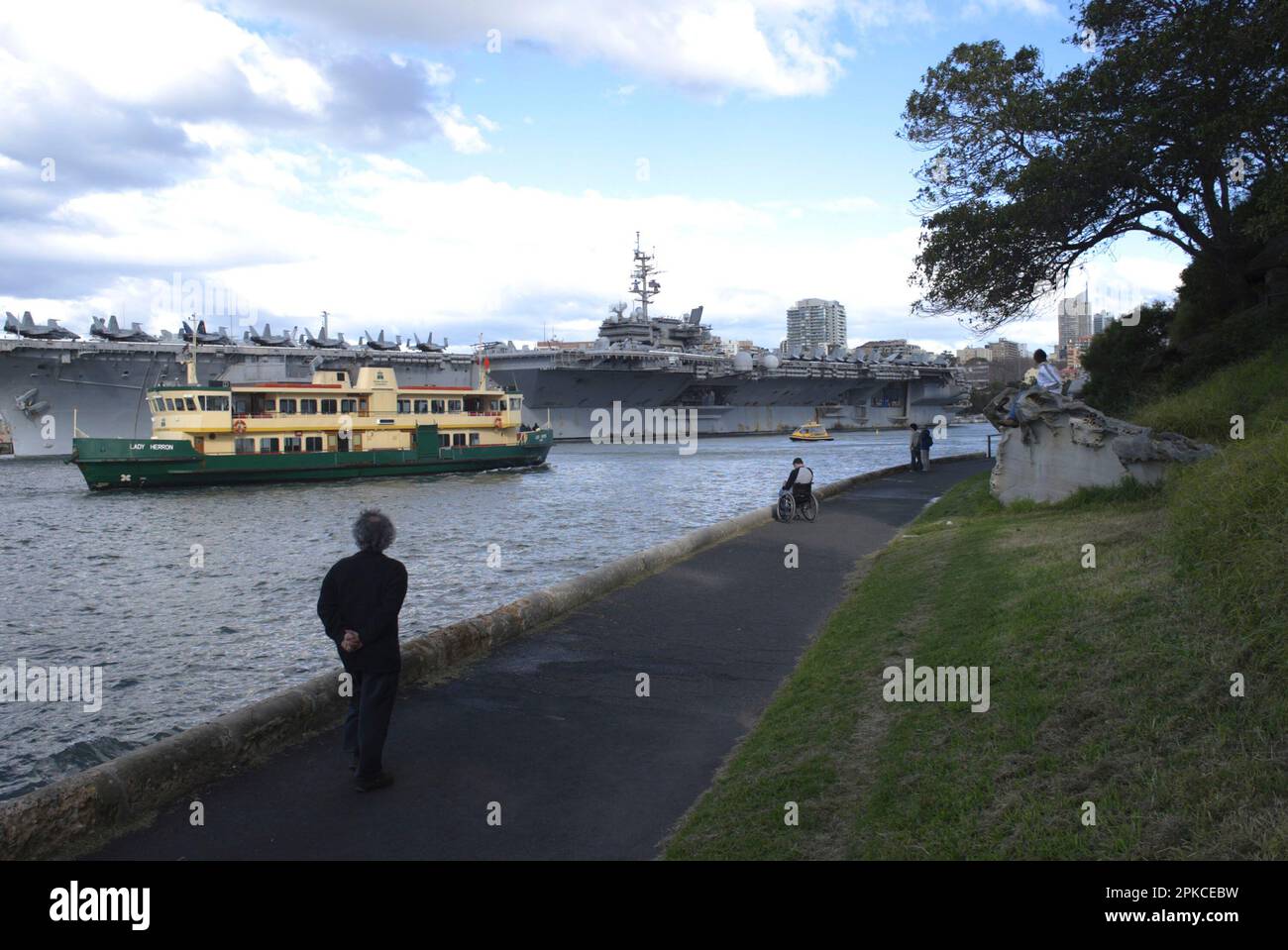 La portaerei US Kitty Hawk, di 46 anni di prossima disattivazione, è stata attraccata nella base navale di Garden Island a Woolloomooloo Bay sul porto di Sydney come parte di un soggiorno di una settimana. L’equipaggio di 5000 persone del super vettore, accompagnato da altre quattro navi della marina statunitense, ha iniettato circa $5 milioni di dollari australiani nell’economia locale durante il suo soggiorno di una settimana che si è concluso il 11 luglio 2007. Sydney, Australia. 11.07.07. Foto Stock