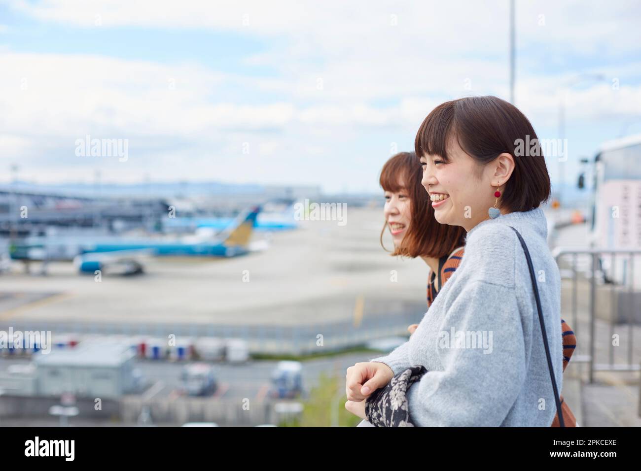Due donne che guardano un aereo in un campo aereo Foto Stock