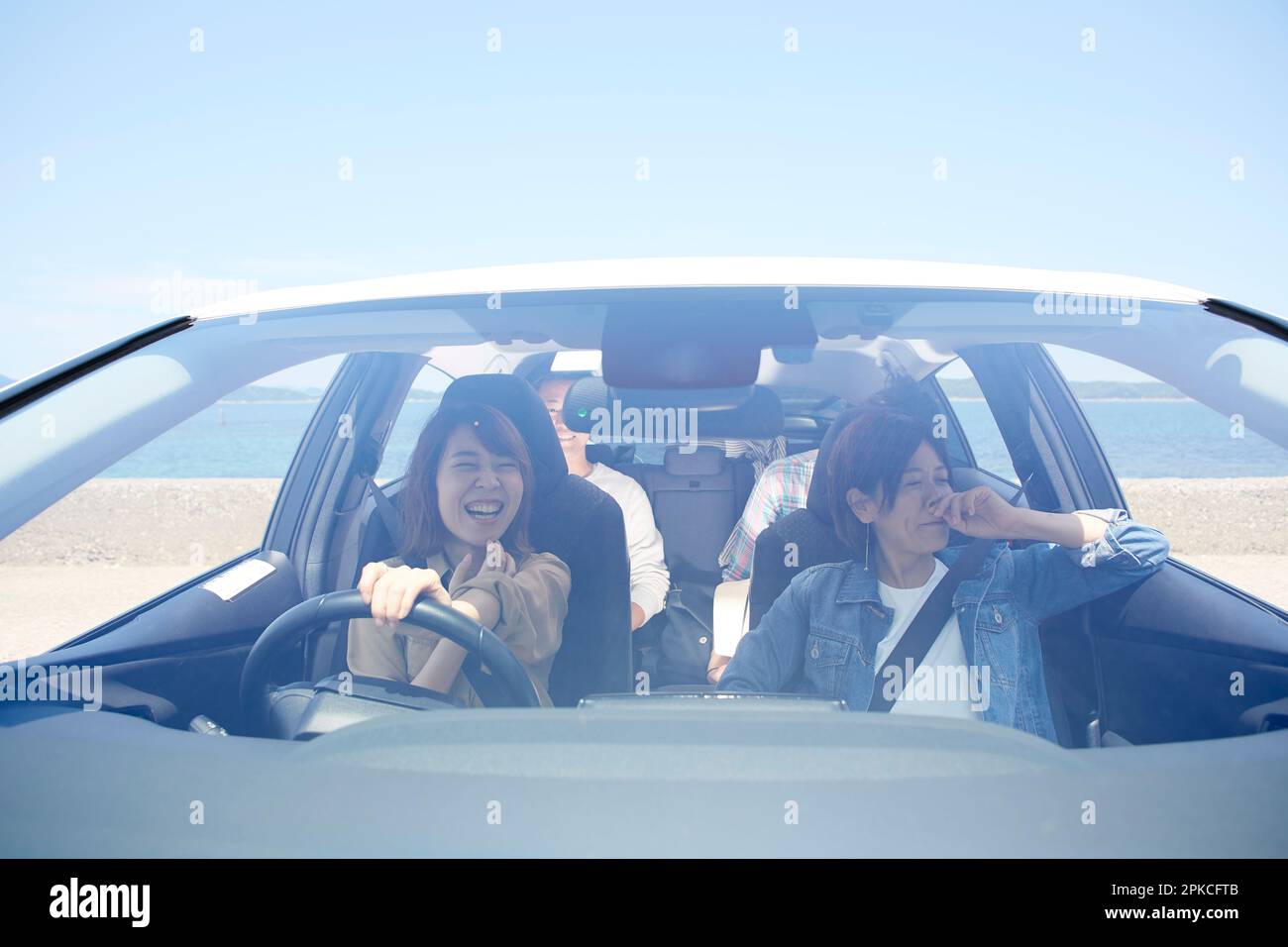 Uomo e donna che guidano, visti dalla parte anteriore della vettura Foto Stock