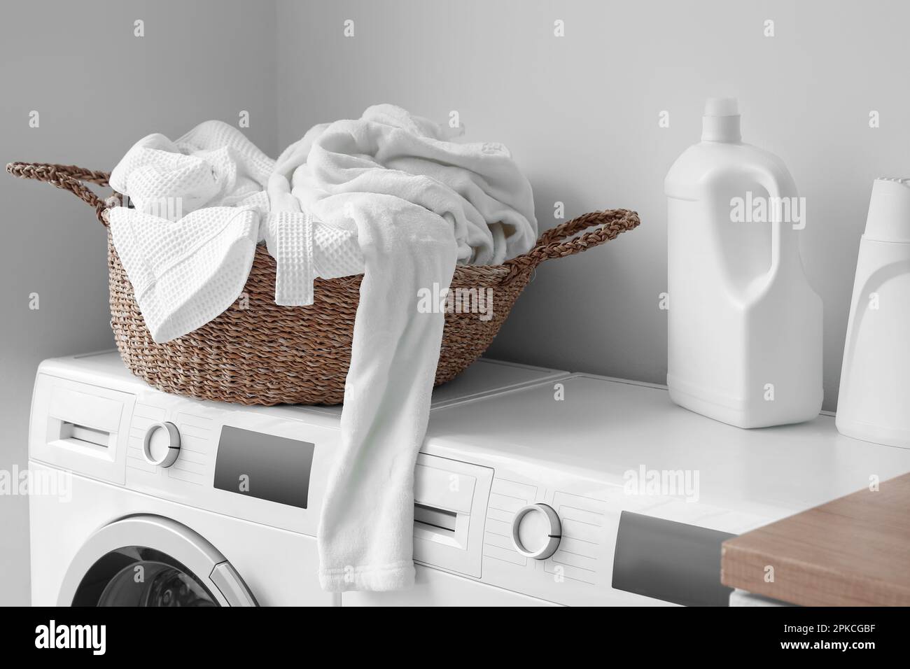 Cestino con vestiti sporchi e detersivo sulle lavatrici in lavanderia Foto  stock - Alamy