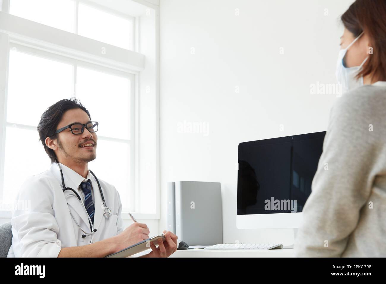 Un medico sorridente che fa un colloquio medico Foto Stock