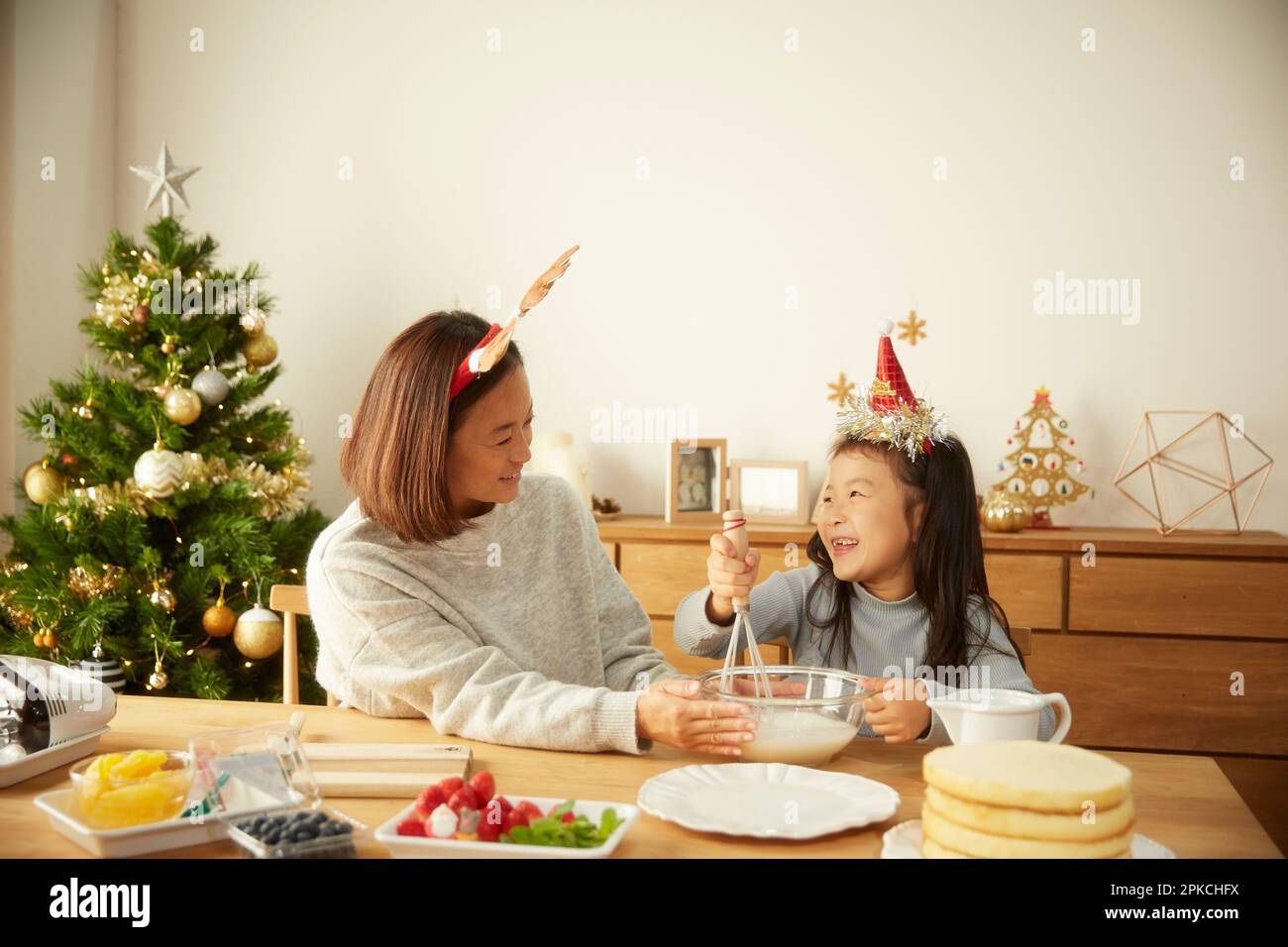Un genitore e un bambino che fanno una torta di Natale Foto Stock