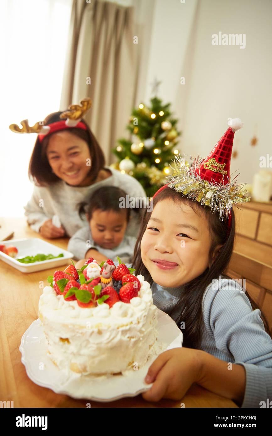 Un genitore e un bambino che festeggia il completamento di una torta di Natale Foto Stock