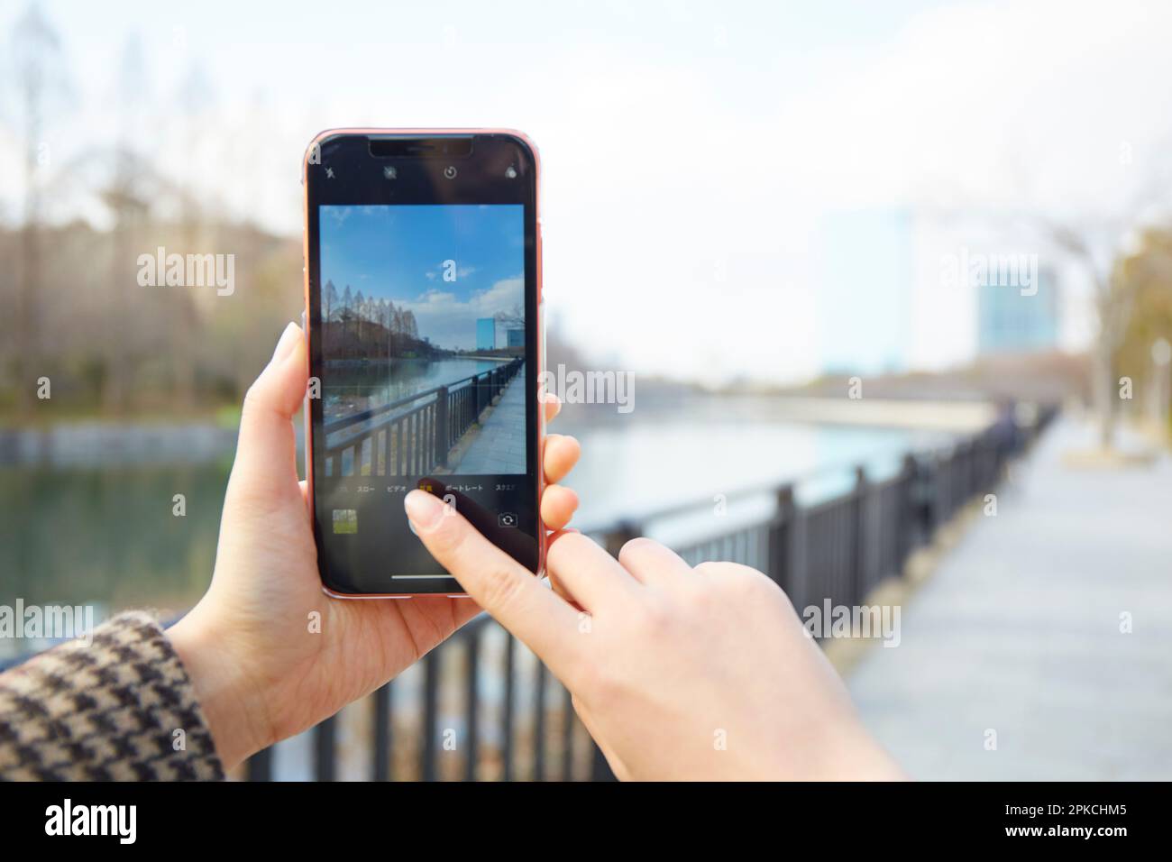 Mano di una donna che fotografa il paesaggio con uno smartphone Foto Stock