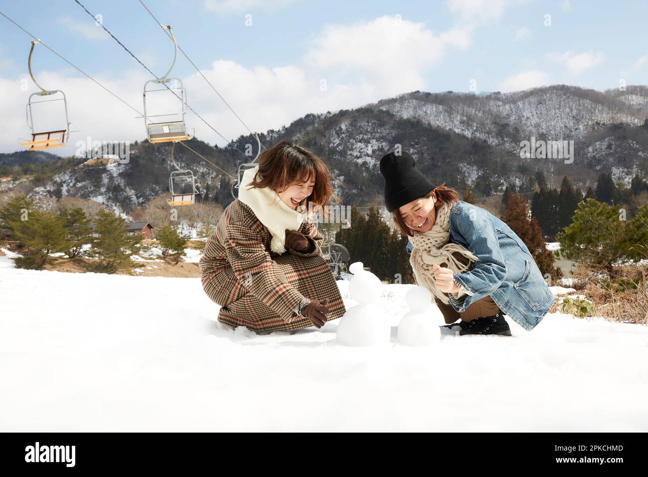 Due donne che costruiscono un pupazzo di neve Foto Stock