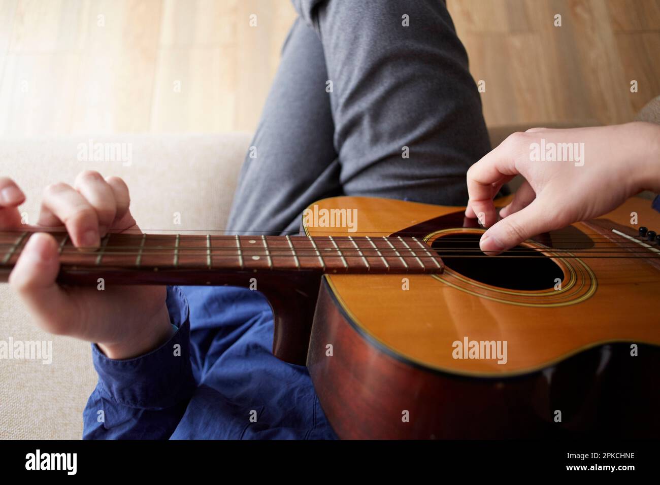 Mano di un uomo che suona la chitarra acustica Foto Stock