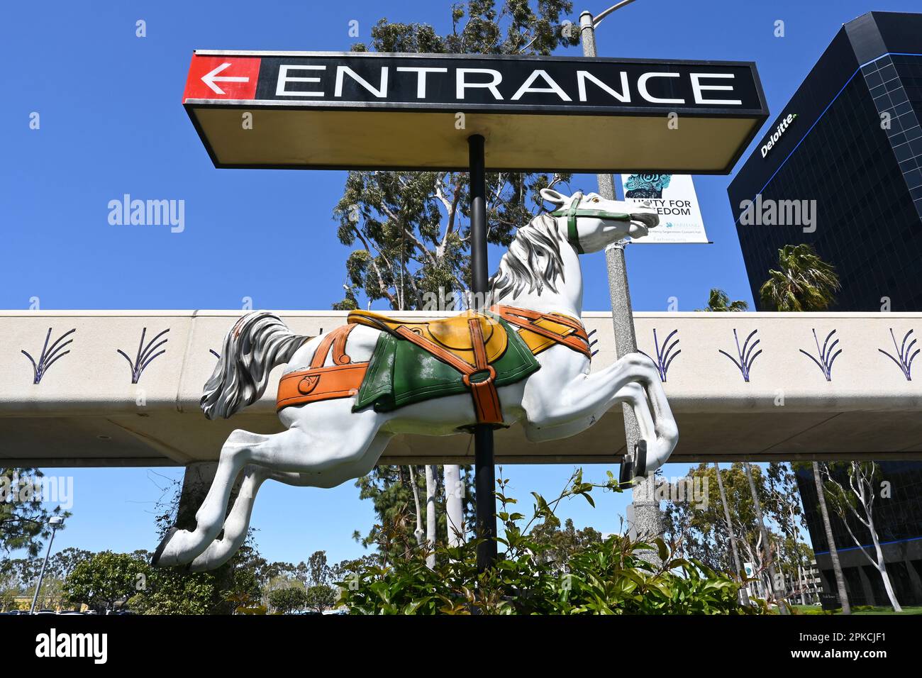 COSTA MESA, CALIFORNIA: 4 Apr 2023: Carousel Horse segna l'ingresso di Bristol Street a South Coast Plaza con il Ponte Unity sullo sfondo. Foto Stock