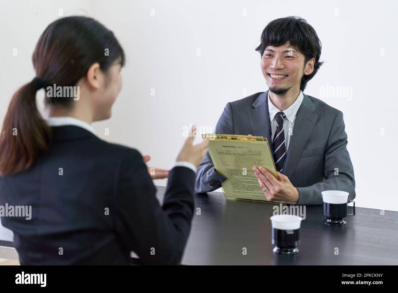 Intervistatore maschile intervistando un ricercatore di lavoro femminile. Foto Stock
