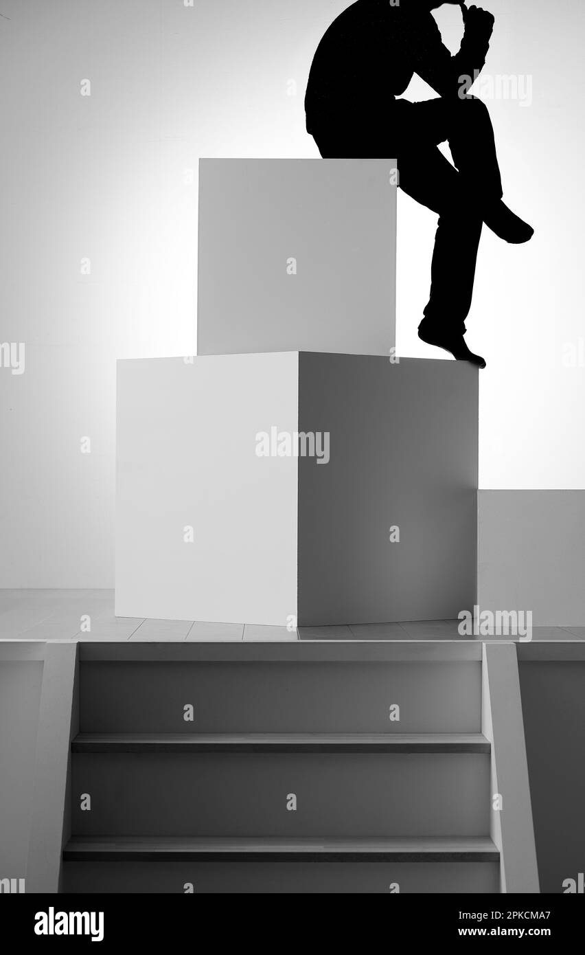Figura seduta su un oggetto fatto di quadrati Foto Stock