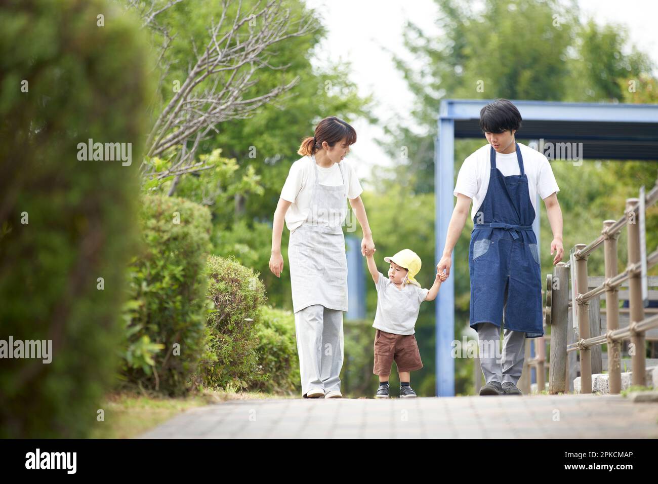 I bambini maschi e femmine che tengono le mani con un bambino Foto Stock