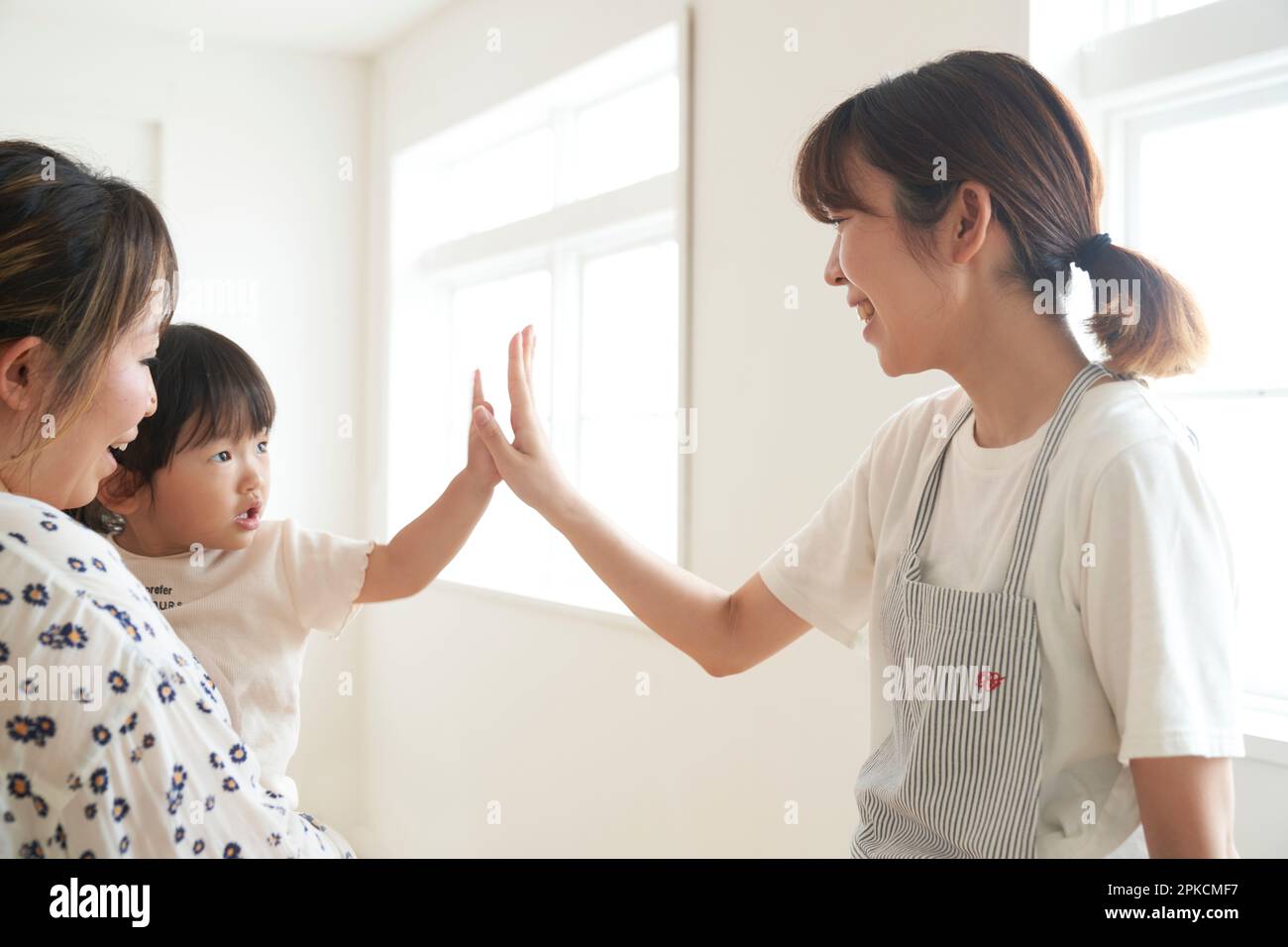 Donna che si occupa della cura dei bambini che tocca un bambino che viene a casa Foto Stock