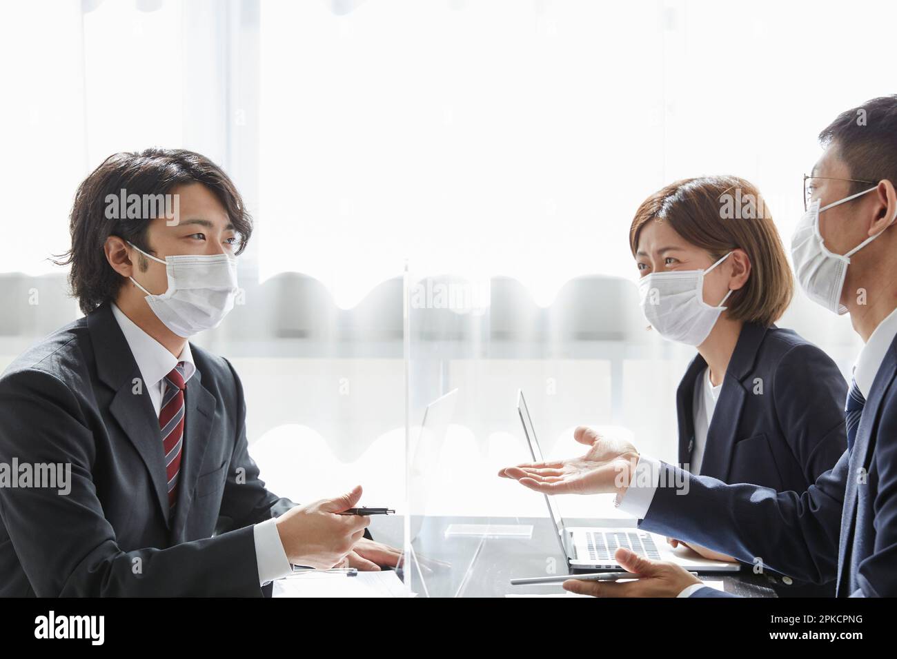 Lavoratore dell'ufficio che ha una riunione di affari con una maschera su Foto Stock