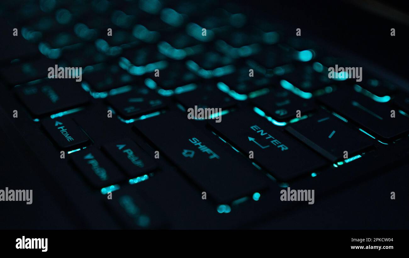 La tastiera di un computer è un dispositivo di input che consente a una persona di immettere lettere, numeri e altri simboli della tastiera con retroilluminazione verde Foto Stock