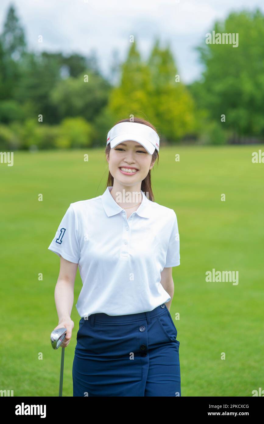 Una donna nel suo 20s giocare a golf Foto Stock
