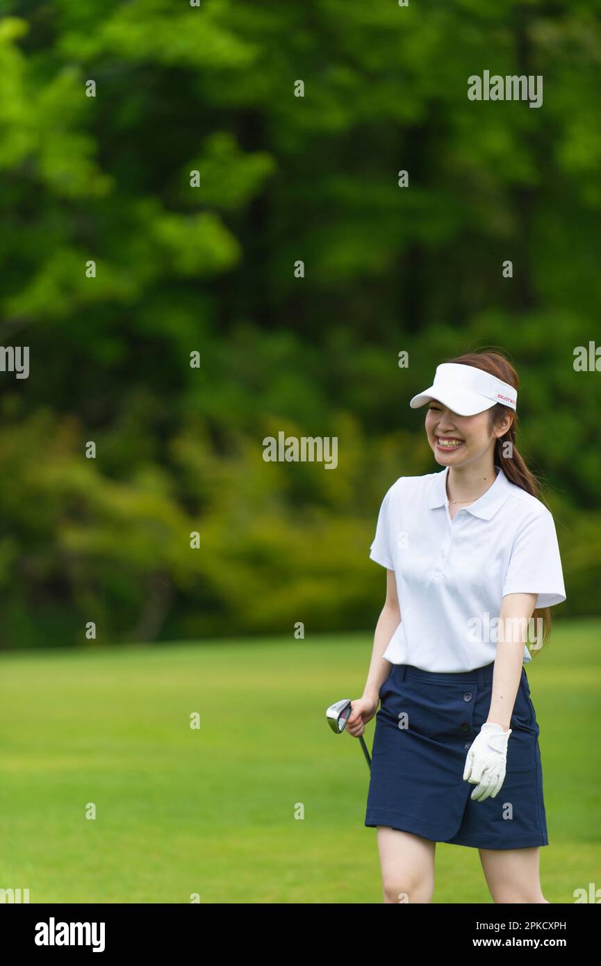 Una donna nel suo 20s giocare a golf Foto Stock