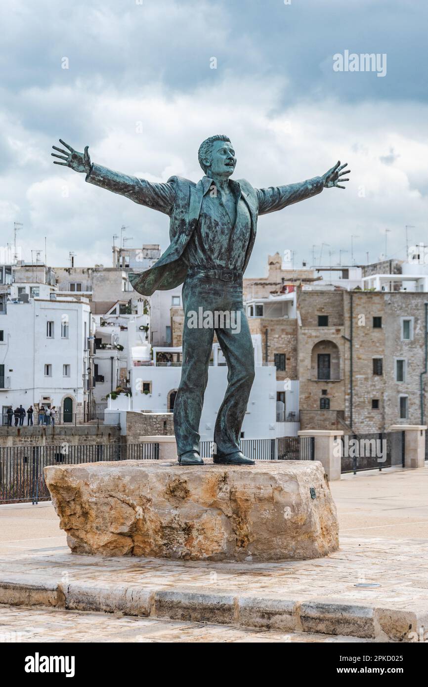 Statua in bronzo del cantante italiano Domenico Modugno che si affaccia sul centro storico sulle scogliere rocciose e sul mare blu a braccia aperte come la famosa canzone volare Foto Stock