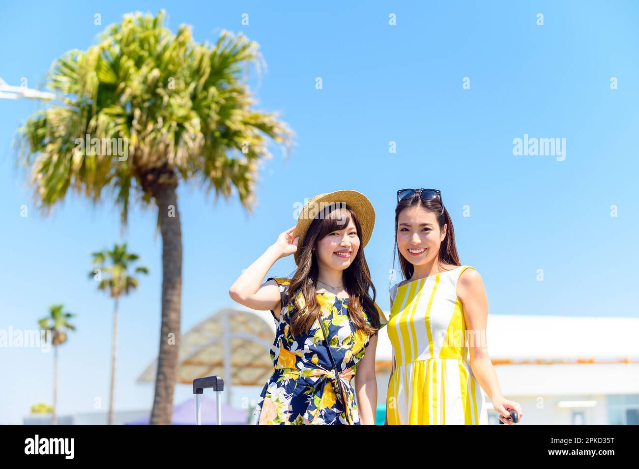 Due donne che viaggiano in una località balneare con una borsa a mano Foto Stock