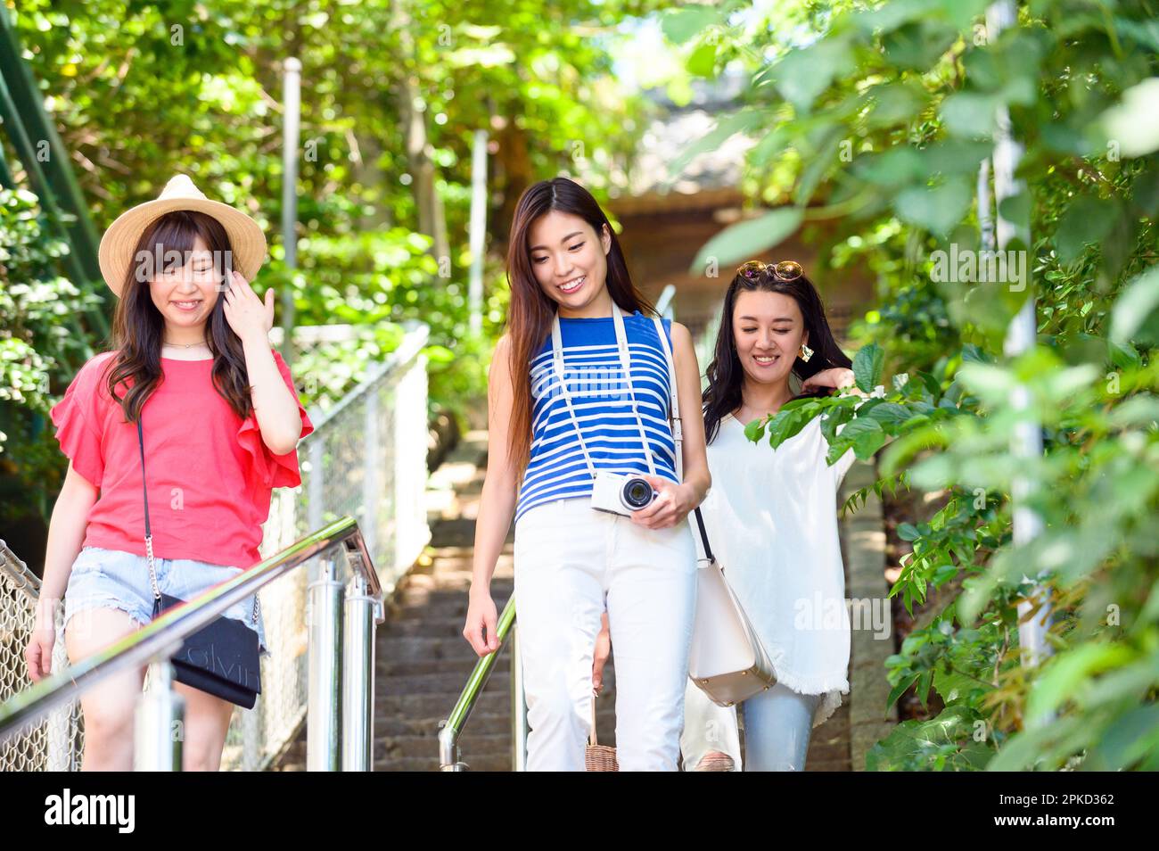 3 donne che viaggiano in un resort dove scendono le scale di un'isola Foto Stock