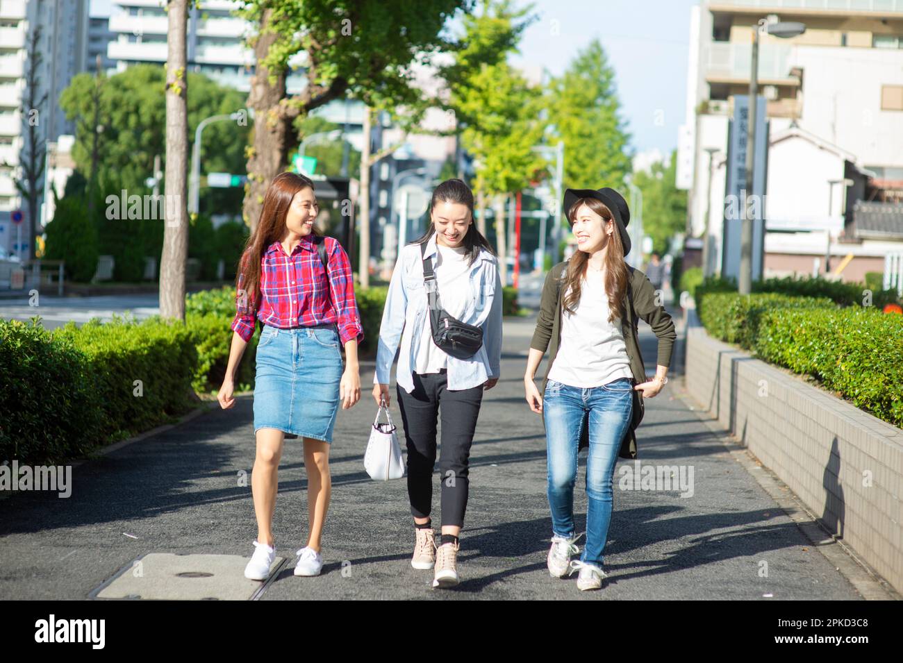 Tre donne in un viaggio delle ragazze a piedi sul marciapiede Foto Stock