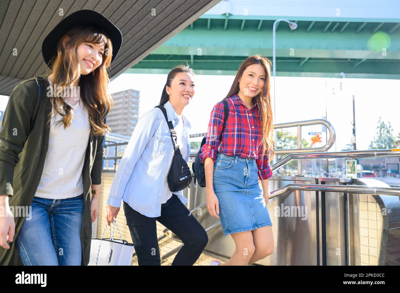 Tre donne in viaggio per ragazze che lasciano una stazione della metropolitana Foto Stock