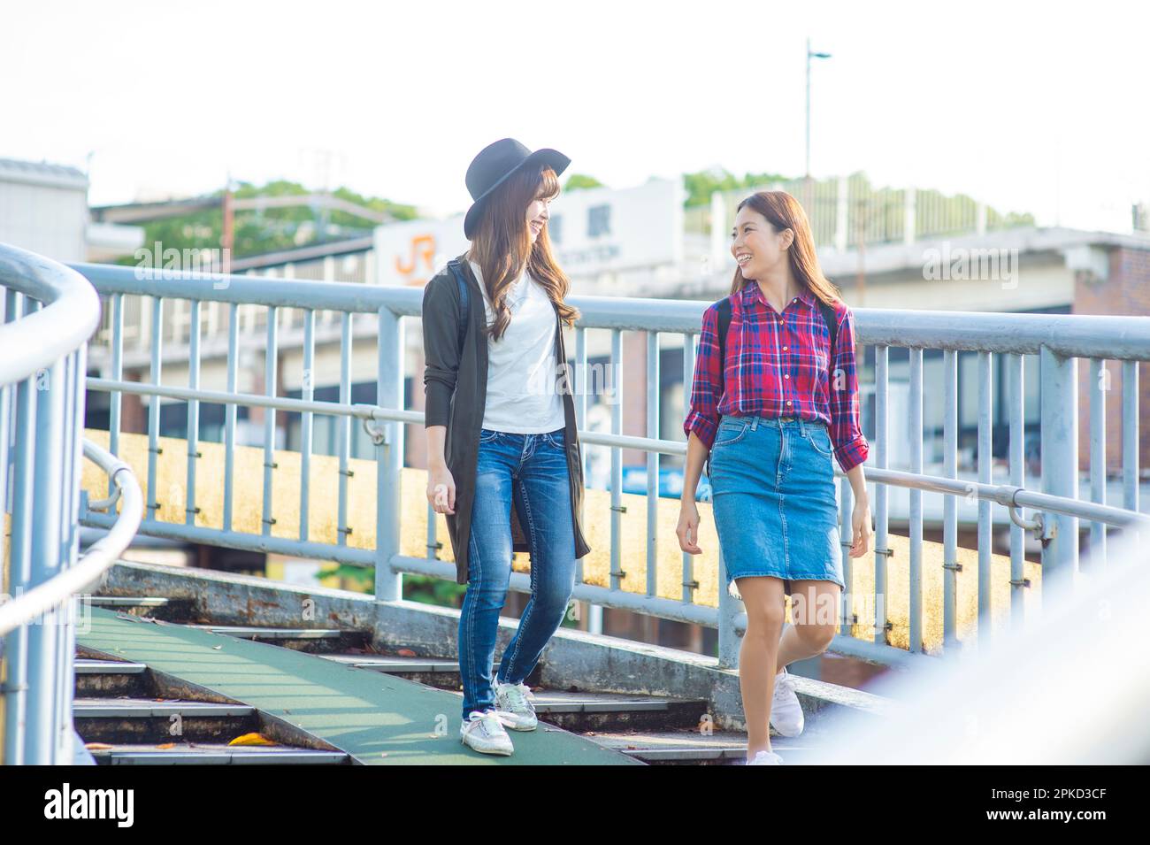 Due donne che camminano sul ponte pedonale Foto Stock
