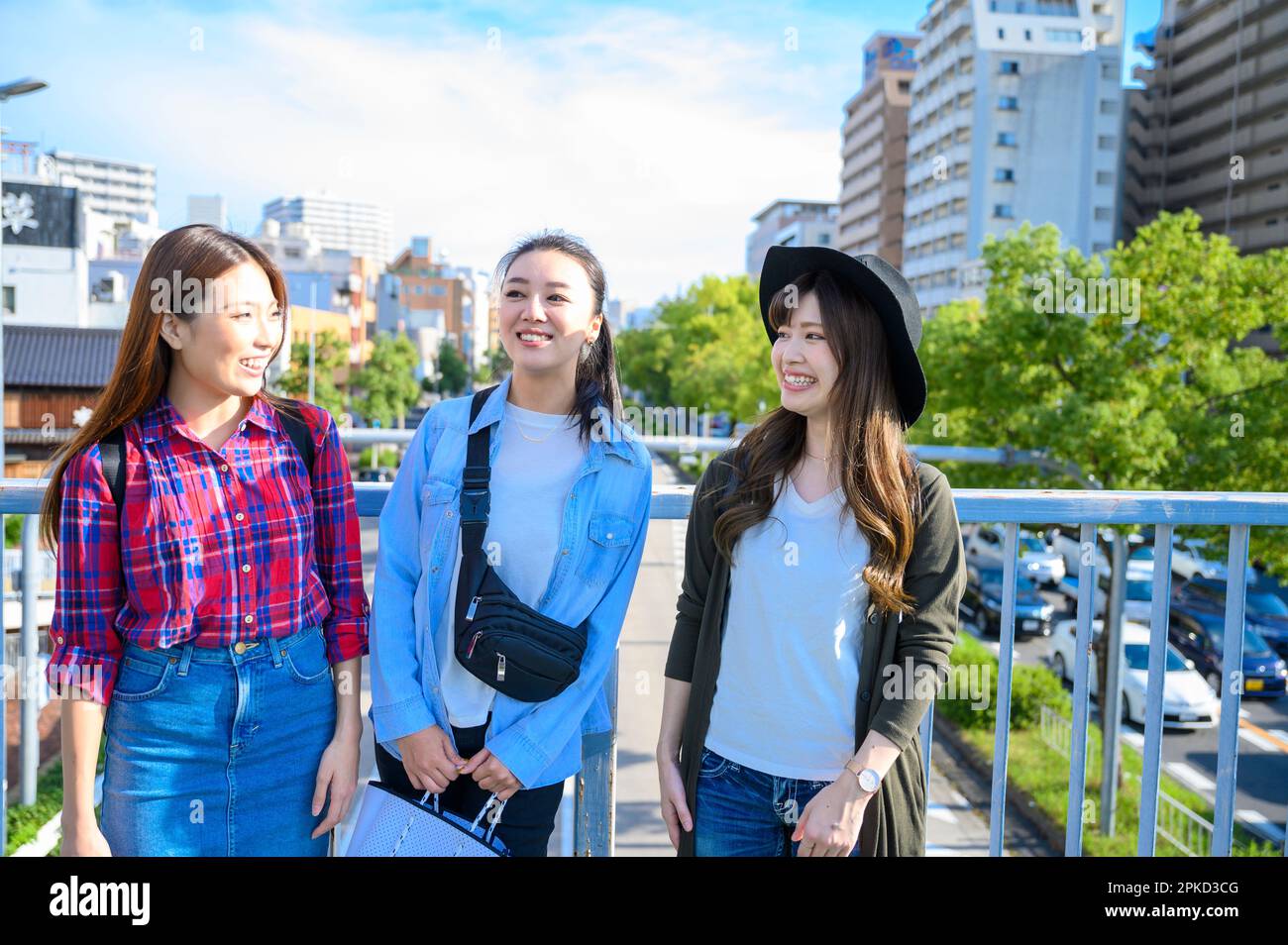 Tre donne in un viaggio per ragazze che guardano il paesaggio da un ponte pedonale Foto Stock