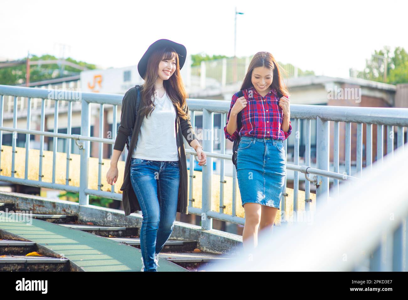 2 donne che camminano sul ponte pedonale Foto Stock