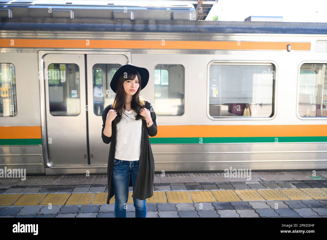 Donna che viaggia sulla piattaforma di un treno Foto Stock