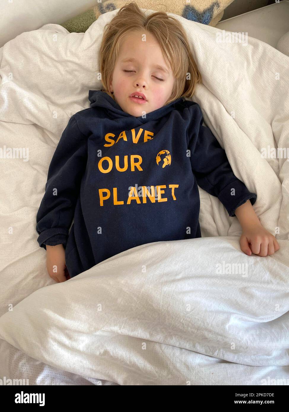 Ragazzo, 4 anni, biondo, con t-shirt SALVARE IL NOSTRO PIANETA, dormire in pace a letto, Stoccarda, Baden-Wuerttemberg, Germania Foto Stock